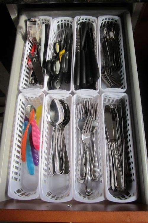 Plusieurs petits bacs blanc qui servent de rangement pour couverts