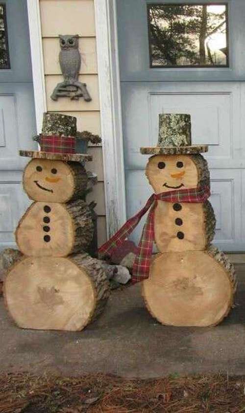 Two outdoor snowmen made with logs 