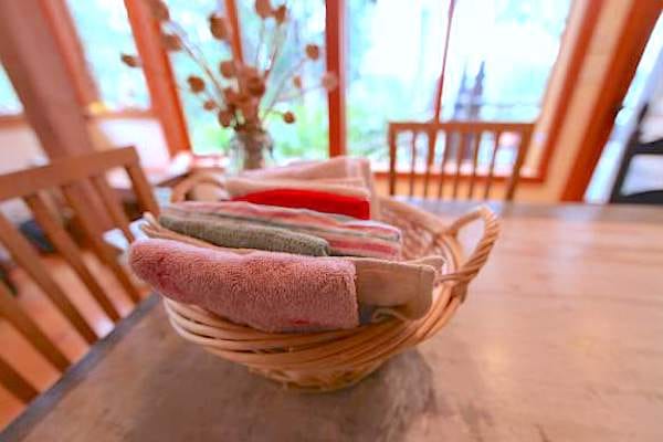 Des torchons en tissu posés sur la table pour remplacer les essuie-tout.