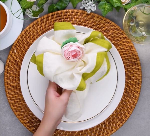Guardanapo dobrado em forma de buquê de flores colocado em um prato branco
