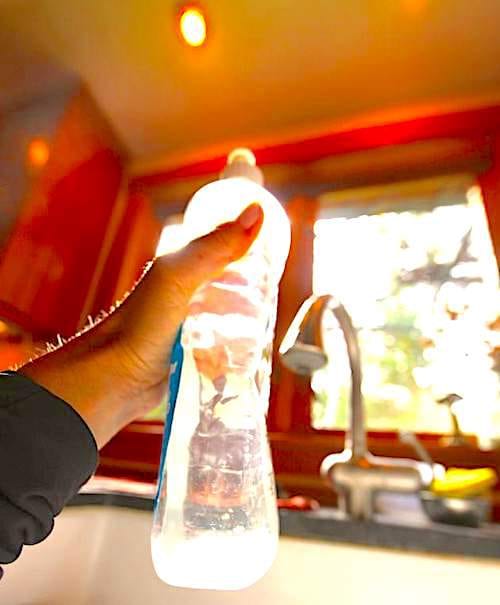 Lumière du soleil qui passe à travers la fenêtre et une bouteille de vinaigre blanc