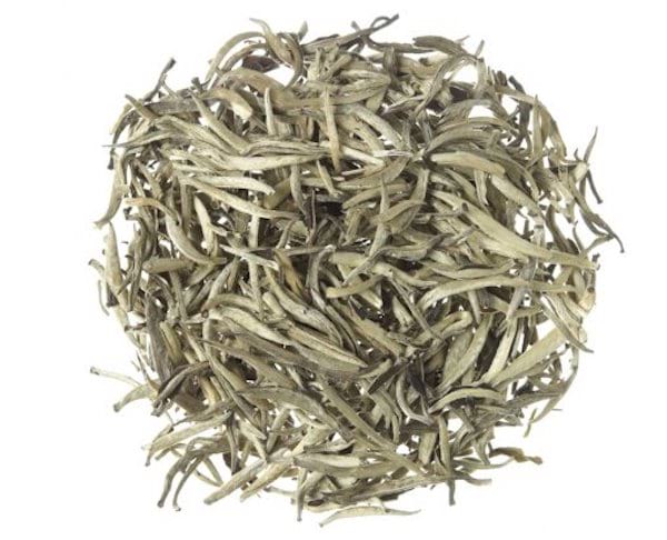 Du thé blanc en vrac, sur fond blanc.