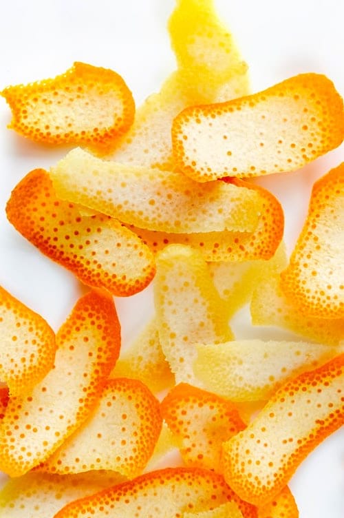 Des morceaux d’écorces d’orange, sur fond blanc.