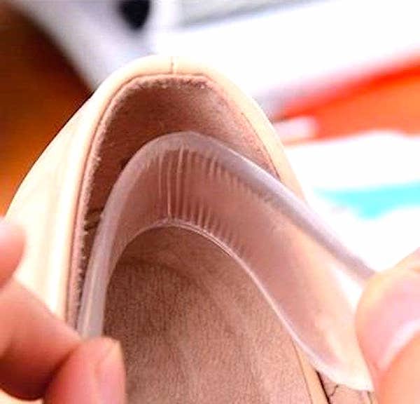 Des mains qui insère un coussinet en silicone à l’intérieur d’une chaussure.