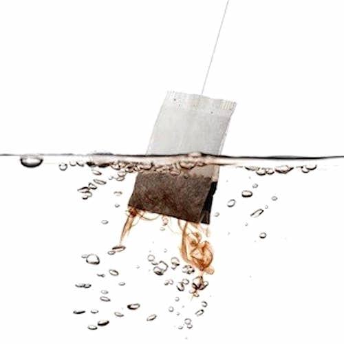 Un sachet de thé dasn de l'eau, sur fond blanc.