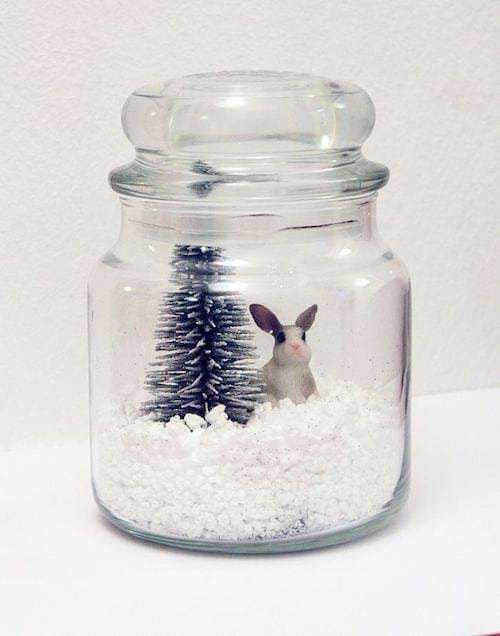 Un bocal en verre avec du gros sel dedans et un petit sapin et un lapin blanc