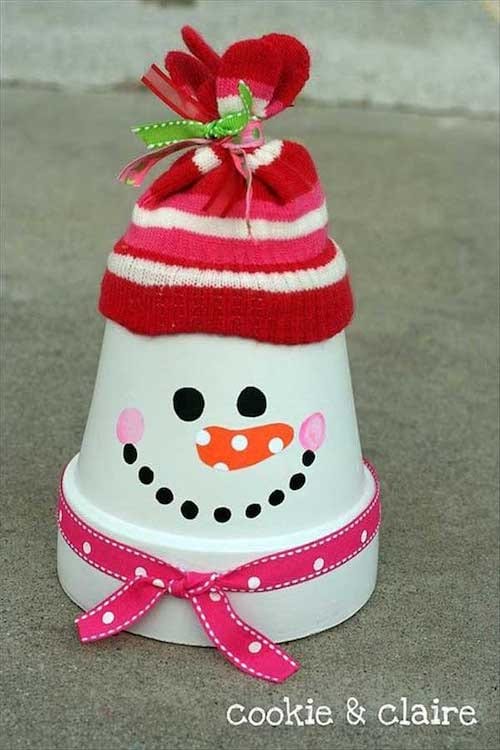Bonhomme de neige en pot de fleurs avec un bonnet rose