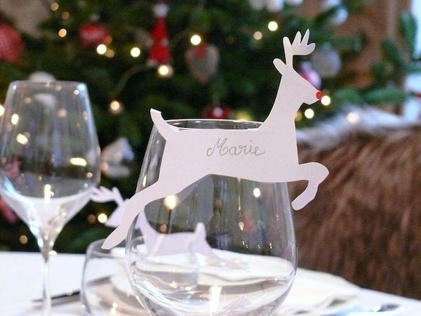 Un marque place en forme de cerf collé sur un verre de la table