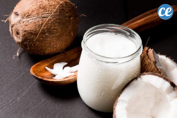 noix de coco entière et cuillère en bois avec de l'huile de coco