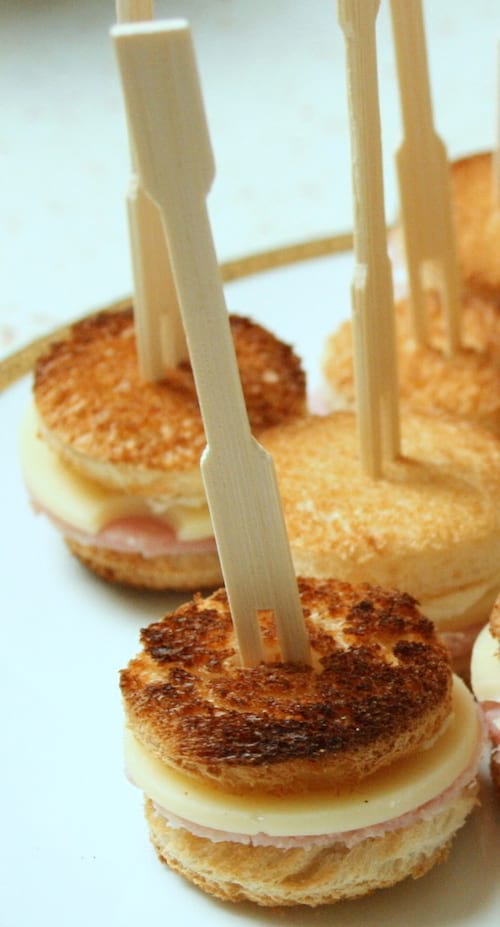 des mini croque-monsieurs de forme ronde présentés avec des piques pour l'apéro.