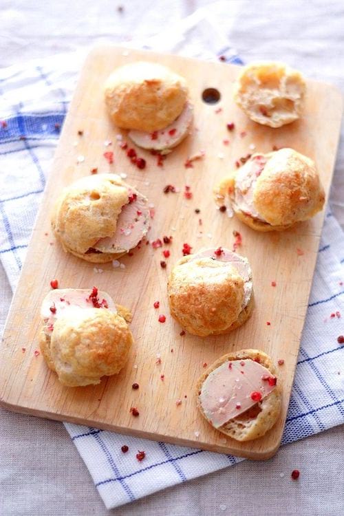 6 gougères au foie gras posées sur une planche à découper en bois