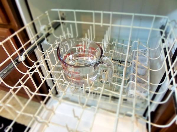Un récipient de vinaigre blanc dans un lave-vaisselle à vide.