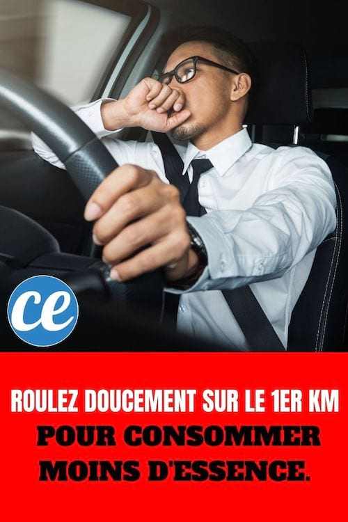Homme tenant un volant dans une voiture : Roulez Doucement sur le 1er km pour Consommer Moins d'Essence.