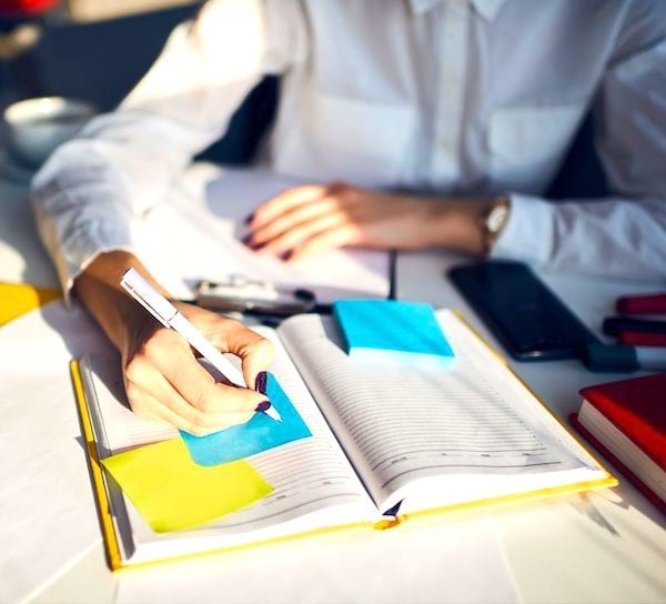 Une femme qui écrit dans son agenda.