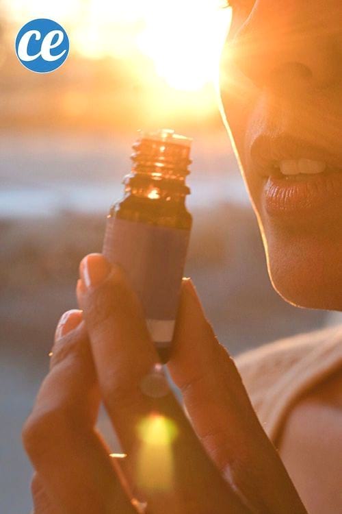 Une femme qui sent un flacon d'huile essentielle à l'extérieur.
