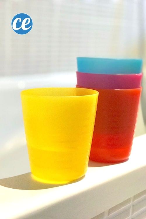 Des verres en plastique colorés remplis d'eau pour faire des jeux et des activités pour les enfants