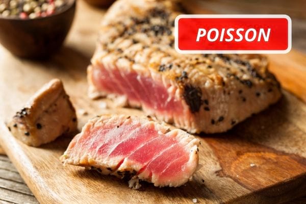 Un pavé de thon rouge grillé, sur une planche en bois.