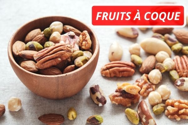 Différentes variétés de fruits à coque dans un bol en bois.