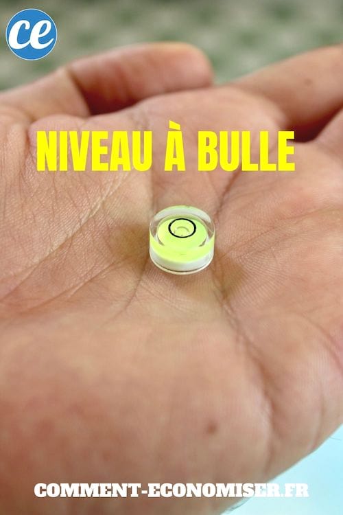 Une main qui tient un niveau à bulle rond.