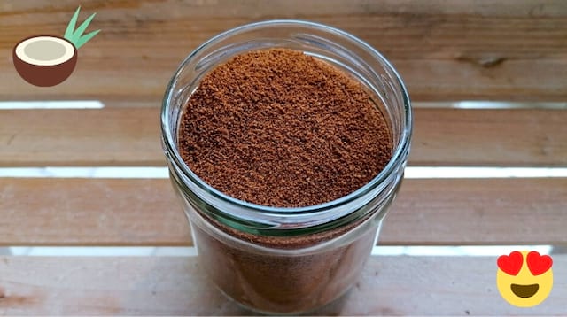 Du sucre de fleur de coco dans un récipient en verre sur une table en bois
