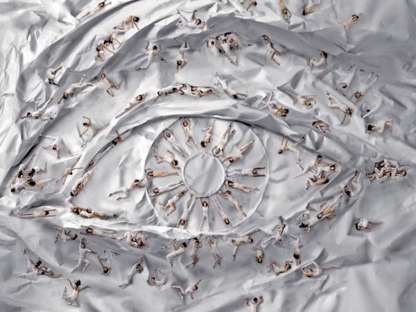 Plusieurs personnes dansant sur du papier formant un oeil 