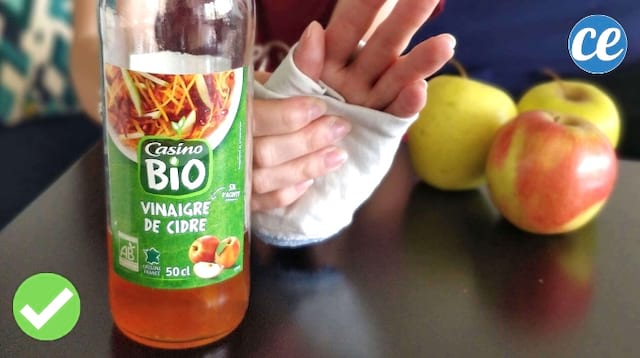Une bouteille de vinaigre de cidre et une main bandée pour calmer les douleurs articulaires