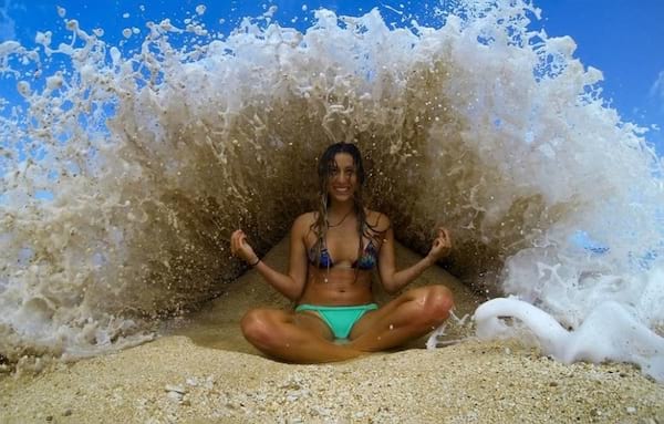 Femme faisant du yoga sur une plage au bord de l'eau 