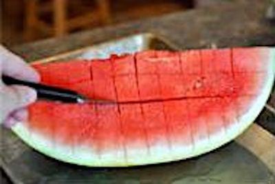 Un couteau qui coupe une grille sur une pastèque.