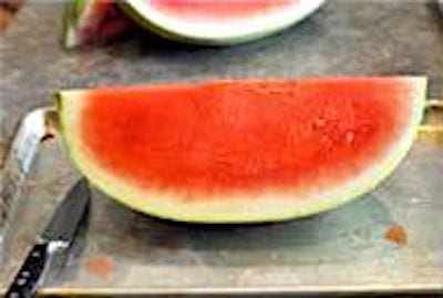 Une pastèque sur une plaque à pâtisserie avec rebords.