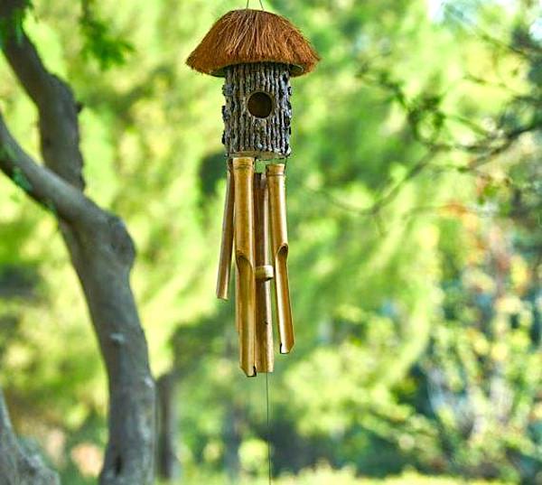 Un carillon à vent suspendu à une branche d'arbre dans un jardin.
