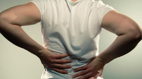 Un homme se tient le dos