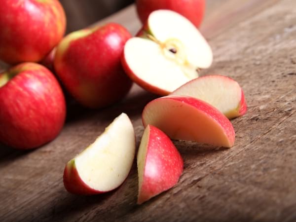 Des pommes rouges sur une table en bois coupée