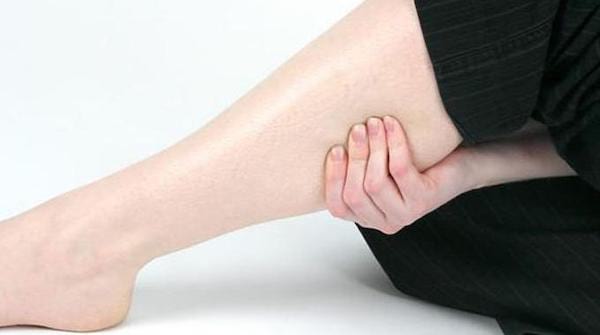 Une personne se tient le mollet parce qu'elle a une crampe 