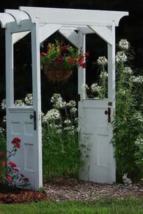 Structure dans jardin avec d'anciennes portes blanche