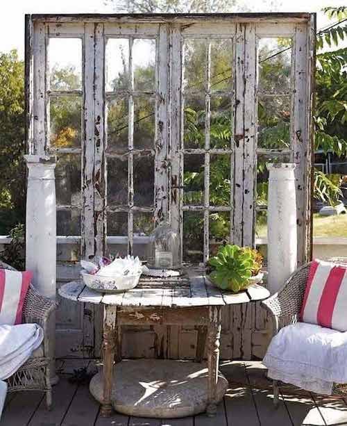 Espace détente dans jardin avec d'anciennes portes autour