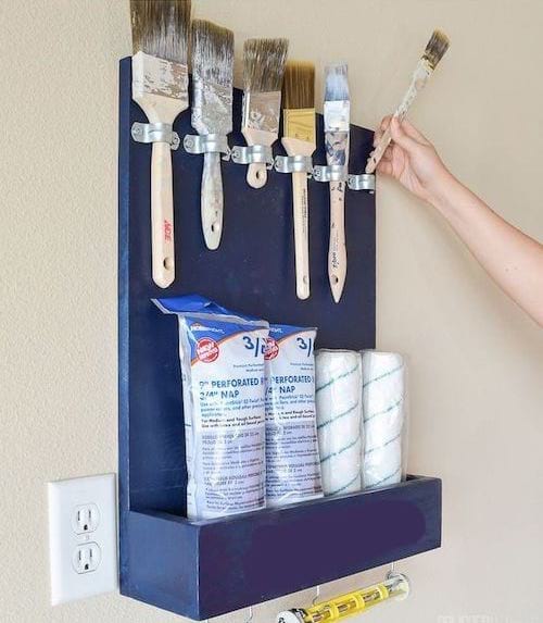 Pinceaux rangés dans une boîte au mur bleue