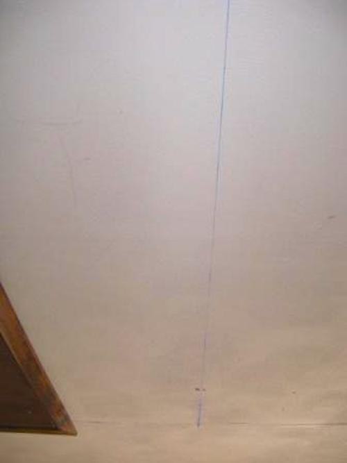 Un trait bleu tracé sur le plafond d'un garage pour marquer l'emplacement d'un guide.