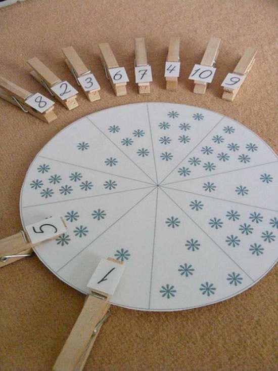 Un jeu fait avec des épingle à linge et un cercle en carton pour associer les chiffres et quantités