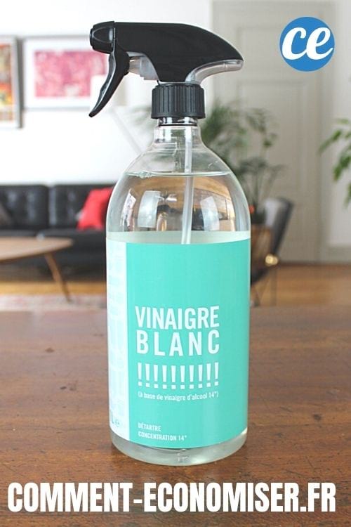 Une bouteille spray de vinaigre blanc sur une table en bois dans une maison.