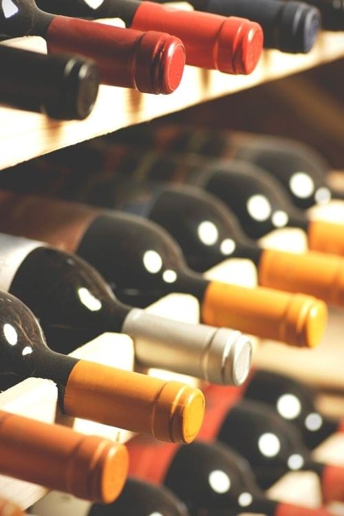 Des bouteilles de vin sur une étagère en bois.