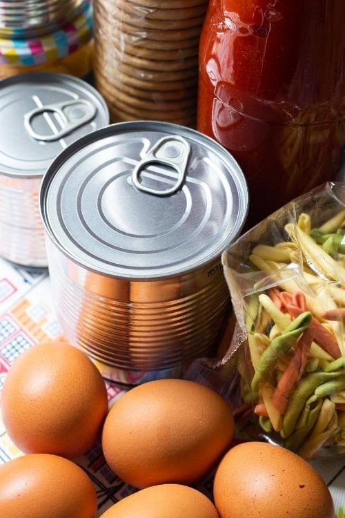 Des conserves, des paquets de pâtes, des bocaux et des oeufs.