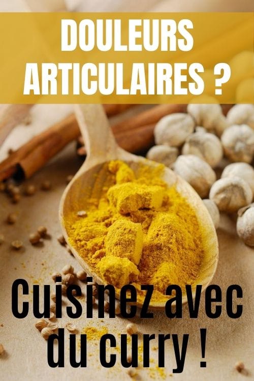 Une cuillère en bois avec du curry jaune en poudre.