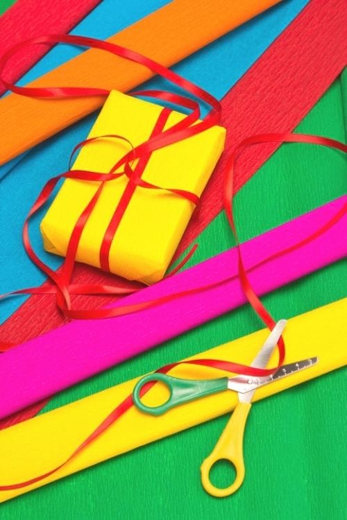 Du papier cadeau, du ruban et des ciseaux aux couleurs vives et éclatantes.