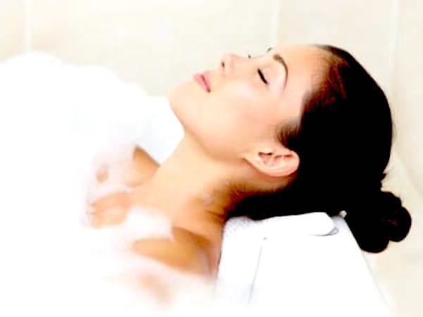 Une femme qui se détend dans un bain détox avec de l’eau oxygénée.