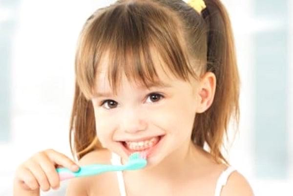 Une jeune fille qui se brosse les dents.