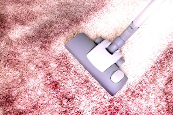 Un aspirateur qui aspire une moquette très sale.
