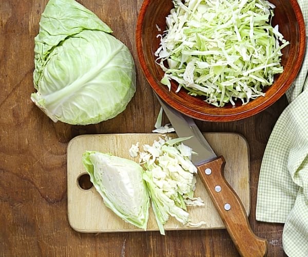 chou blanc coupé en lamelle sur une planche en bois