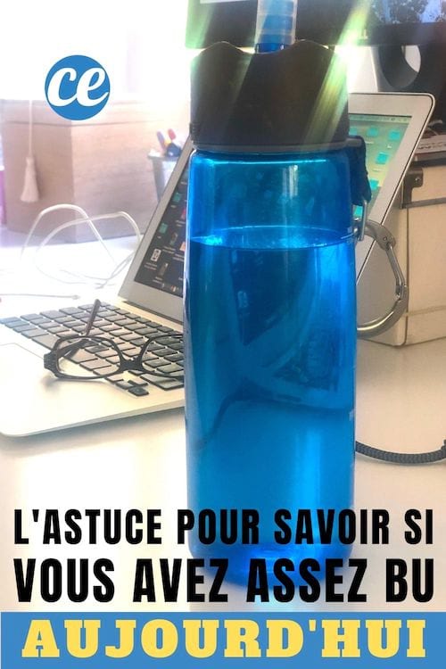 Une gourde bleue remplie d'eau près d'un ordinateur