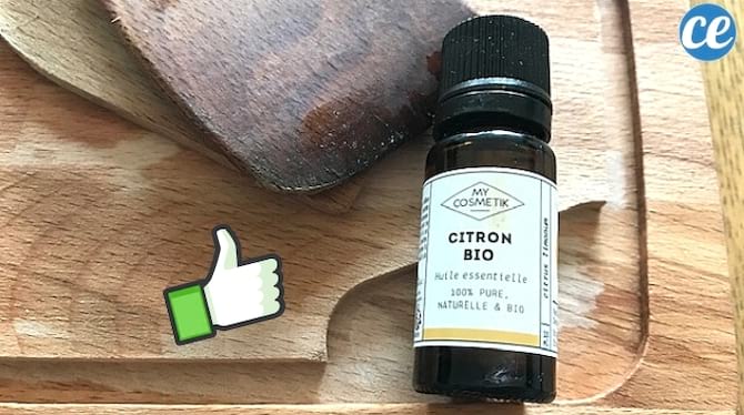 deux cuillères en bois dans un plat et bouteille d'huiles essentielles de citron