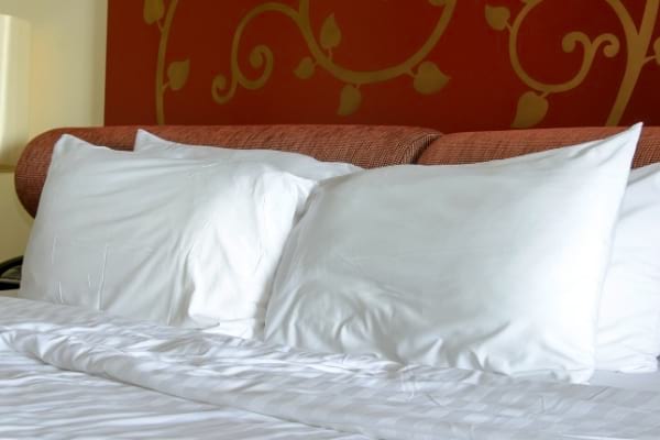 Des oreillers propres sur un lit rouge